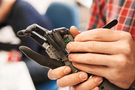 Man scientist twisting with screwdriver contacts in mechanical plastic hand