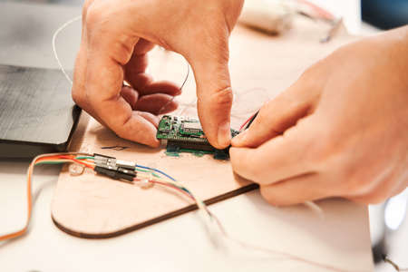 Male engineering working in laboratory, using voltage and current tester