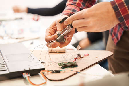 Male engineering working in laboratory, using voltage and current tester