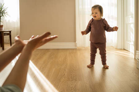 Woman stretching hands to her daughter with down syndrome while playingの写真素材