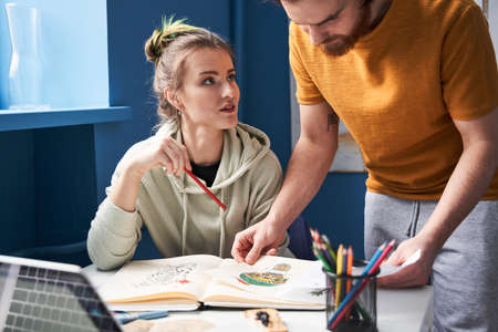 Man looking at the sketches while his woman consulting with him