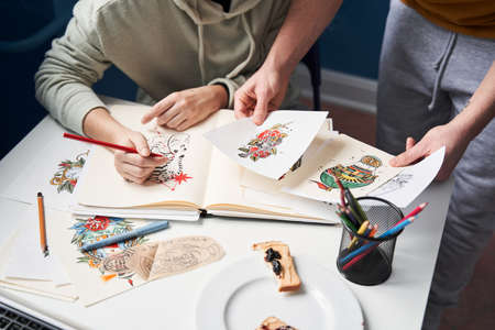 Loving couple considering sketches while working at the kitchen at homeの写真素材