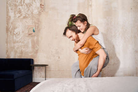 Man holding his wife at his back while woman laughing and bonding