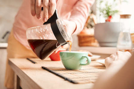 Gay couple enjoying breakfast while drinking coffee and eating croissantsの写真素材