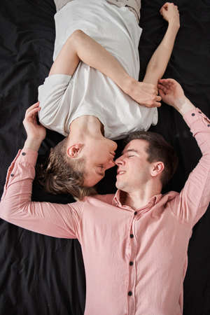 Delighted homosexual couple enjoying being together at home