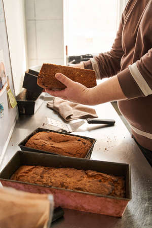 Baker putting cakes at the molds for the sale while working at the baker house