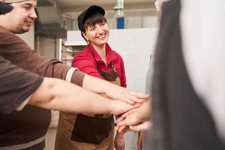 Coolinary team putting their hands together while standing at the workplaceの写真素材