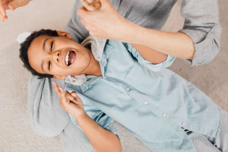 Boy laying at the knees of his granny and showing his emotionsの写真素材