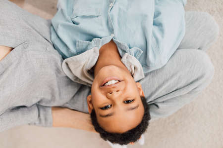 Boy laying at the knees of his grandmother and smiling to the cameraの写真素材
