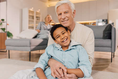 Father embracing his multiracial son with tenderness and posingの写真素材