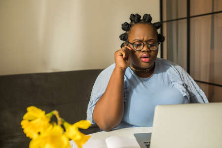 Female vlogger editing video on laptop while working at homeの写真素材