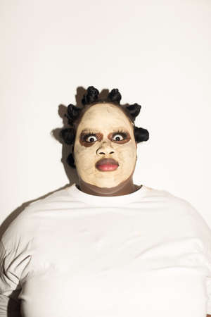 Woman with mask at her face looking at the camera with big surprised eyesの写真素材