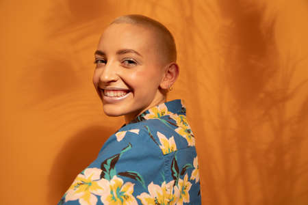 Woman with piercing looking coquettish of her shoulder while posingの写真素材