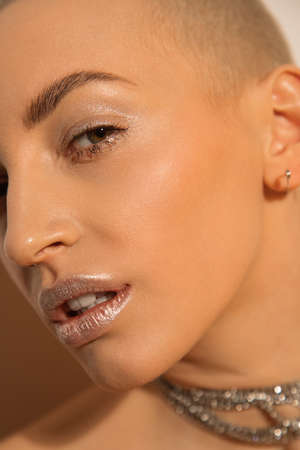 Woman looking at the camera attentively while posing in front of the white wallの写真素材