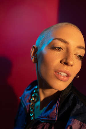 Woman with makeup and short hair is looking away while standing behind camera