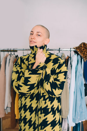 Woman with short hairstyle standing and wearing stylish coat while posing