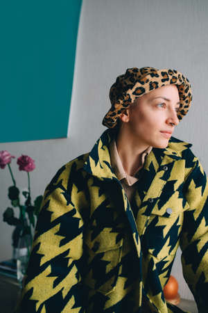 Woman with short hair wearing stylish panama looking at the window while posing