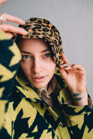 Woman with septum at her nose holding with her hands her leopard panamaの写真素材