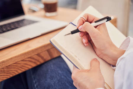 Businesswoman making notes in notebook