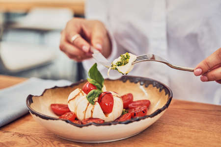 Close up shot of woman eating salad in restaurantの写真素材