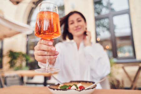 Attractive girl drinking aperitif in restaurant terraceの写真素材