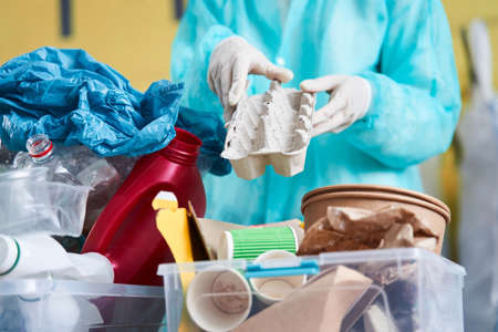 Worker in protective gown holding the cardboard