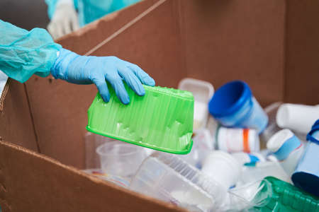 Woman holding green crumpled plastic container