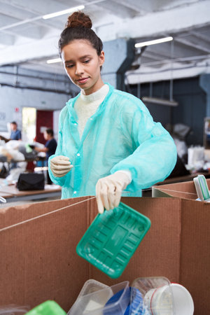 Woman putting plastic wastes at the sorting boxの写真素材