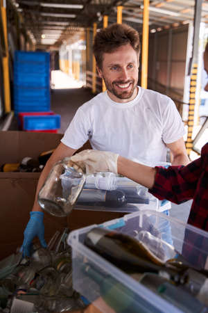 Man unpacking transparent containers with glass bottles