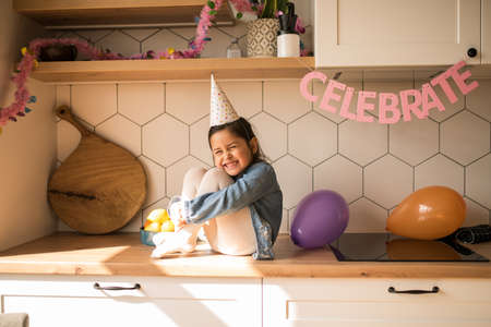 Girl laughing out loud while having great mood during her birthday party at homeの写真素材