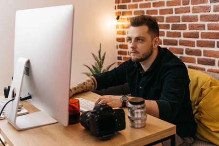 Caucasian man with photo camera and computerの写真素材