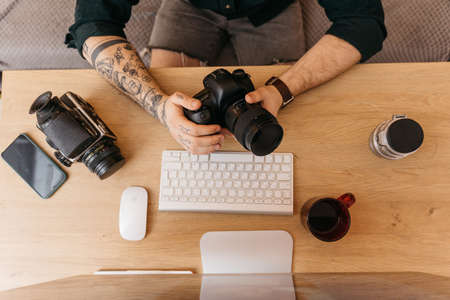 Man checking settings at his camera before the shooting at his own studioの写真素材