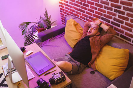 Photographer yawn and stretching while relaxing at his workplace