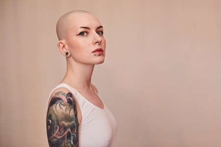 Bald masculine woman posing fashionably with serious emotionsの写真素材