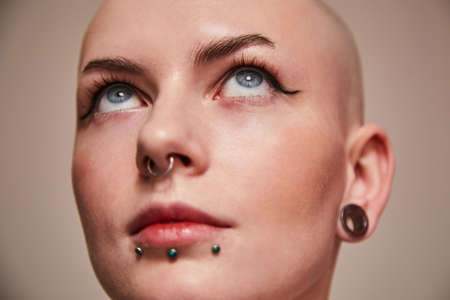 Masculine bald woman with piercing at her faceの写真素材