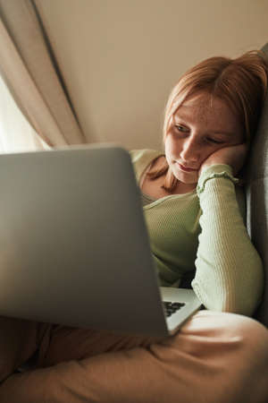 Girl watching something at the computer at the distance educationの写真素材