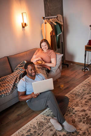 Man looking at the laptop screen with toothy smile while chatting with friends