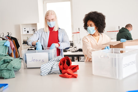 Woman and her male albino colleague wearing protective masks examining clothesの写真素材
