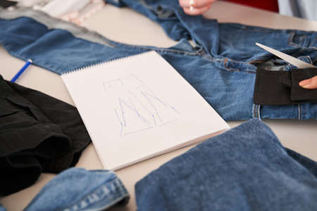 Sketch laying at the table around the different jeans being ready for the re sewingの写真素材
