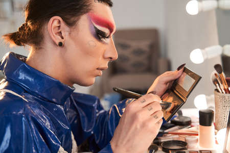 Drag queen holding blushes and collects them on a brushの写真素材