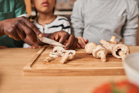 Father having fun while teaching his little daughter cooking