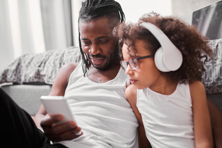 Multiracial girl looking at the smartphone screen while choosing songの写真素材