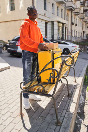 Delivery man taking out a paper package with something