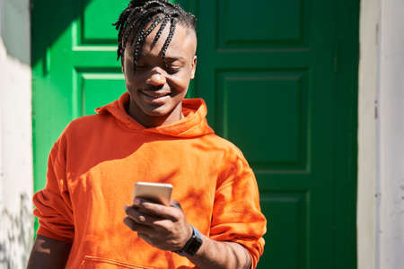 Delivery man using smartphone outdoors after the delivering order