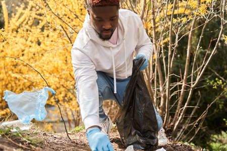 Young man pick up spring forest at the morningの写真素材
