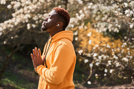 Man standing around the trees and keeping hands in namaste gestureの写真素材