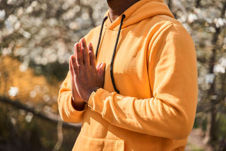 Mindful peaceful multiracial man with a calm look meditating outdoor