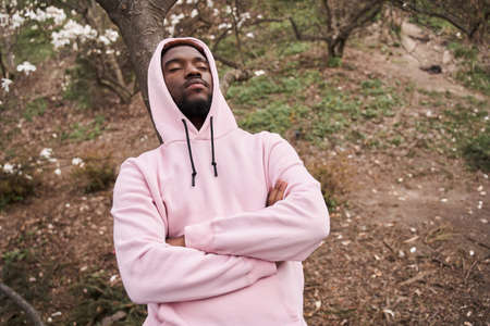 Man wearing casual sweatshirt standing arms crossed at the forest or parkの写真素材