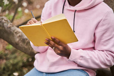 Man holding a notebook and pen while studying at the lonely forestの写真素材