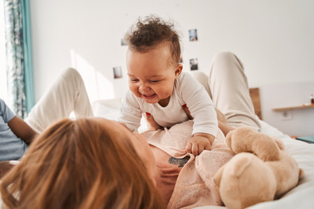 Woman holding her beautiful newborn boy at her hands and enjoying
